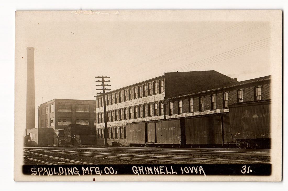 RPPC Spaulding Mfg. Co. Factory, Grinnell, Iowa, Exterior View with Train Cars, Early 20th Century: The front of this Real Photo Postcard (RPPC) displays a sepia-toned photographic image of the Spaulding Mfg. Co. in Grinnell, Iowa. The composition features a sprawling industrial complex comprised of