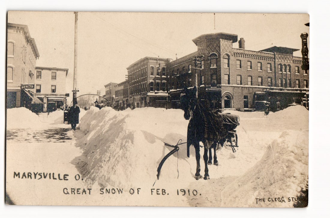 Marysville, O. Street View, Horse-Drawn Sleigh, Great Snow of Feb. 1910. Real Photo Postcard: The front of this Real Photo Postcard (RPPC) displays a sepia-toned photographic image capturing a street scene in Marysville, Ohio, heavily impacted by the "Great Snow of Feb. 1910," as indicated by
