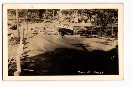 Main Street, Onset: Scene of Destruction with Beached Sailboat, Uprooted Trees, Debris, RPPC