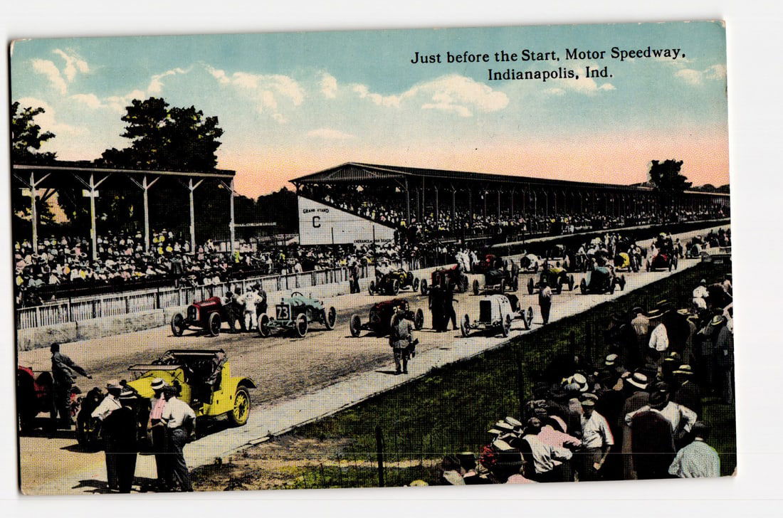 Indianapolis Motor Speedway: Pre-Race Scene with Antique Cars and Spectators, Indiana, c.1910s: The front of the postcard displays a colorized photographic scene at the Motor Speedway in Indianapolis, Indiana. Printed text in the upper right reads: "Just before the Start, Motor Speedway, Indiana