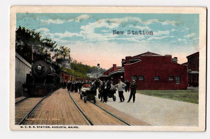 M. C. R. R. New Station in Augusta, Maine, with train and people on platform. Colorized postcard.