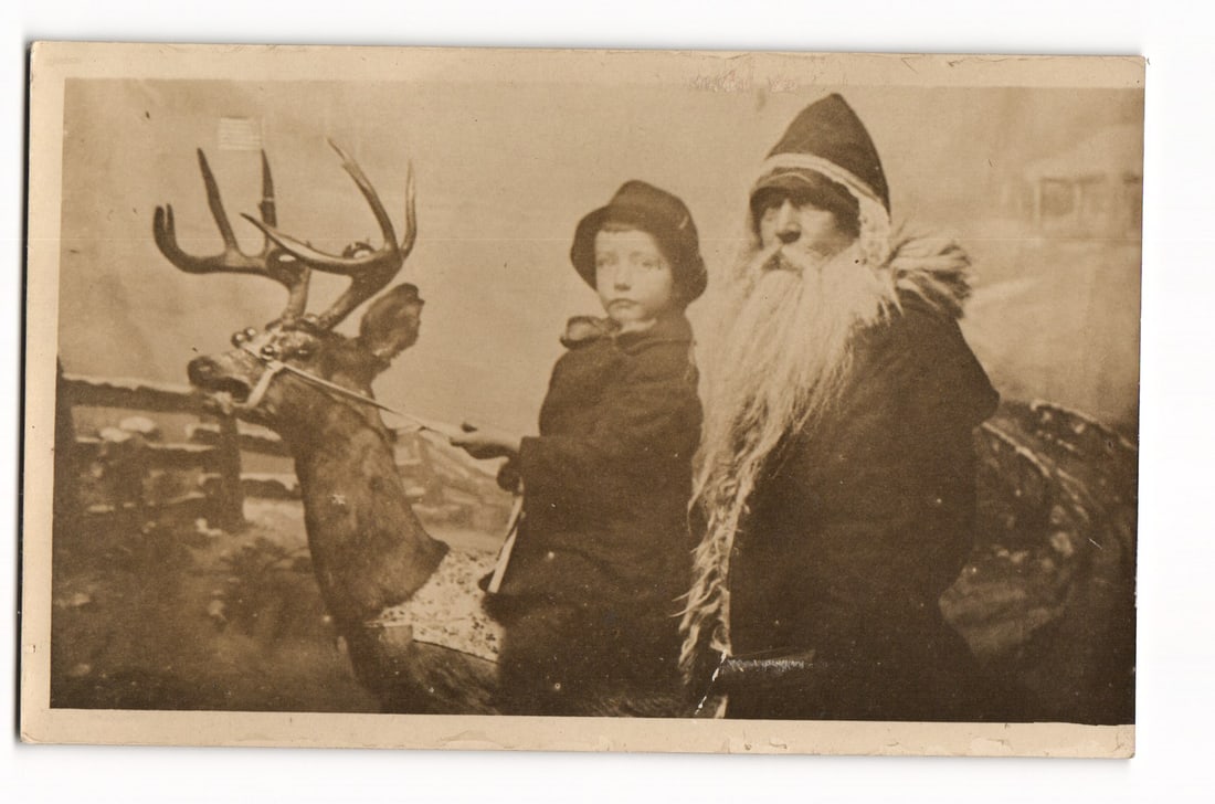 Sepia Real Photo Postcard: Santa Claus with Child and Reindeer in Studio Portrait, circa 1900s. (1 of 2)
