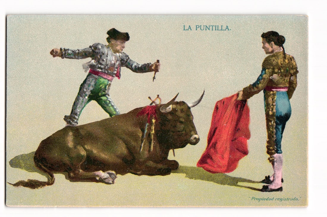 La Puntilla Bullfighting Scene: Two Matadors and Bull, Early 20th Century Color Postcard: A color illustration depicts a bullfighting scene. On the left, a matador, dressed in a silver and green sequined "traje de luces" (suit of lights) with a black montera (hat), stands over a fallen dar