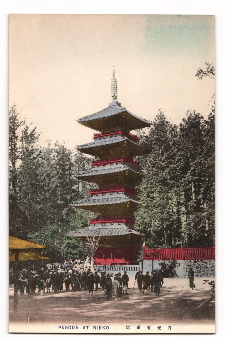 Colorized Photograph Postcard: Pagoda at Nikko, Japan with Crowd and Forest, Early 20th C.: An early 20th century original antique postcard depicting a tall five tiered pagoda its sections colored in red and dark grey or blue set against a backdrop of dense evergreen trees under a pale sky.