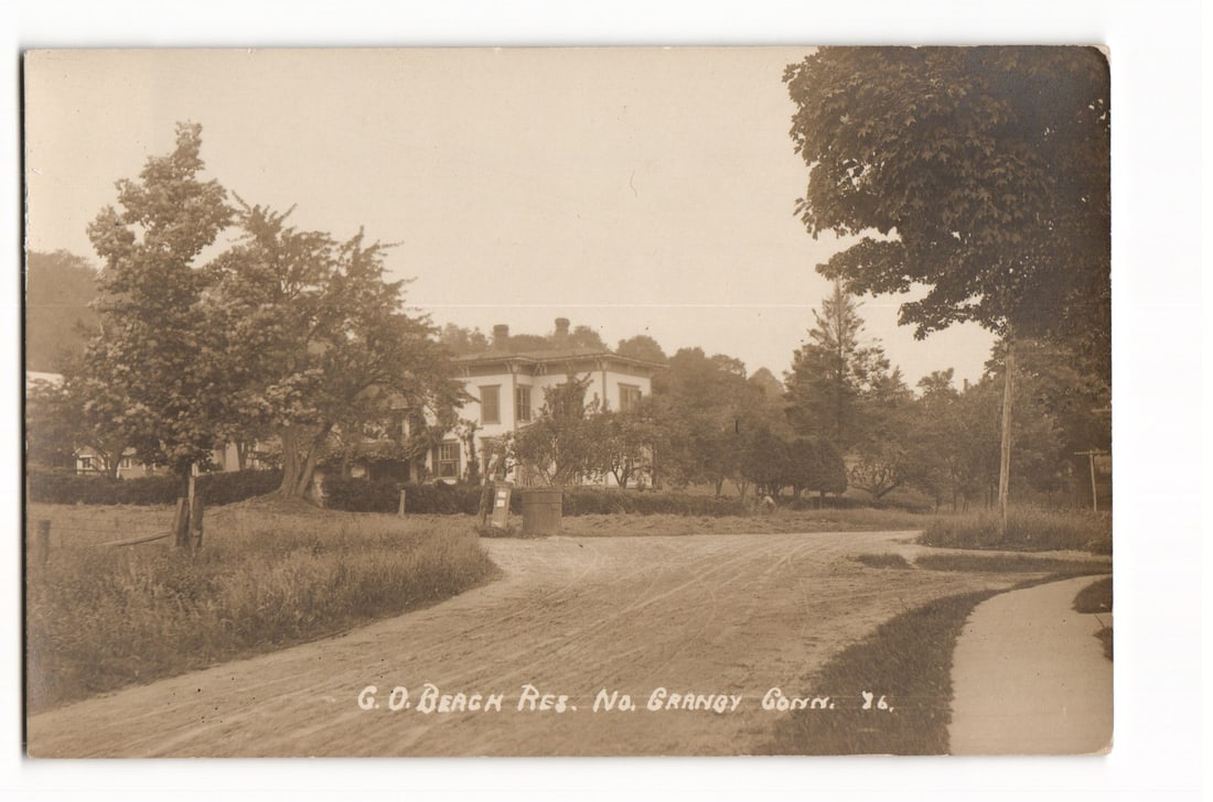 RPPC Postcard G.O. Beach Residence No. Granby Connecticut USA Early 20th Century Road View: This item is a real photo postcard (RPPC) with a sepia tone, featuring a horizontal orientation. The photograph depicts the residence identified as "G. O. BEACH RES." located in "No. GRANBY CONN.". Th