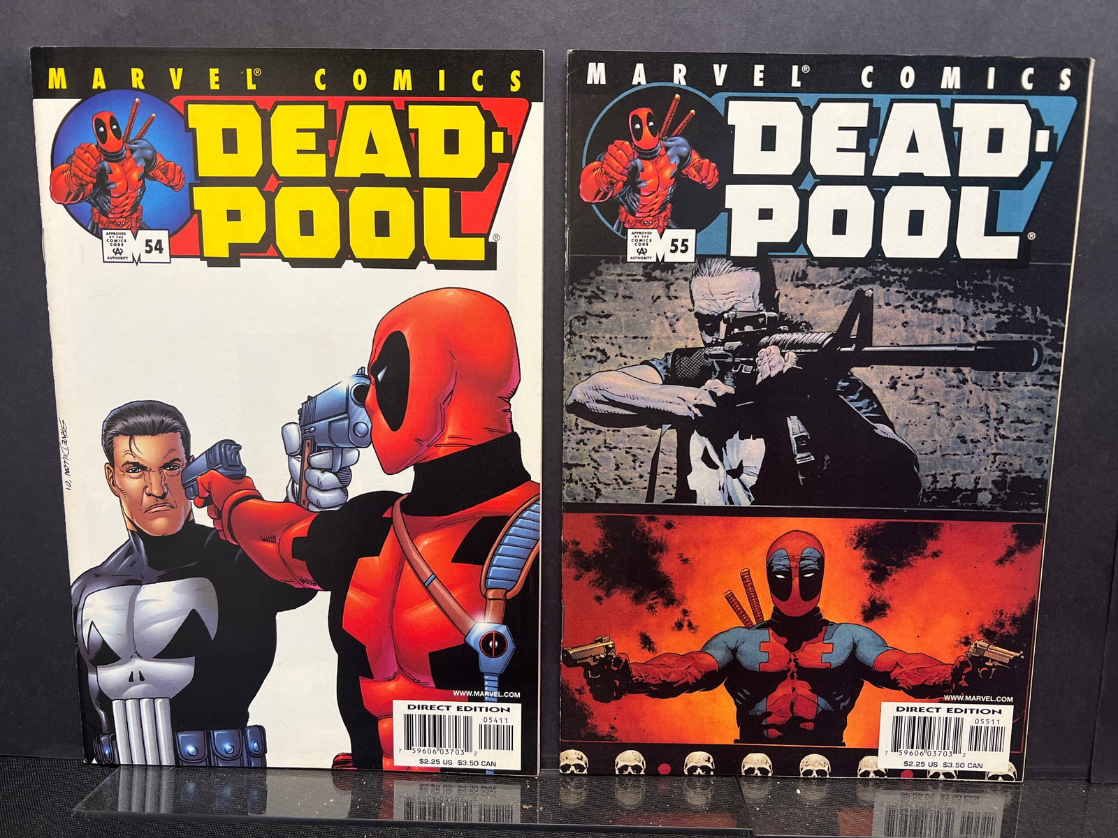 Deadpool #54 & #55 (2001) Marvel Comic Books, The Punisher Appearance, Steve Dillon Cover Art: This lot comprises two Marvel comic books: Deadpool #54 and Deadpool #55, both Direct Edition copies. The cover of issue #54, featuring art by Steve Dillon, shows Deadpool aiming a pistol at The Punis