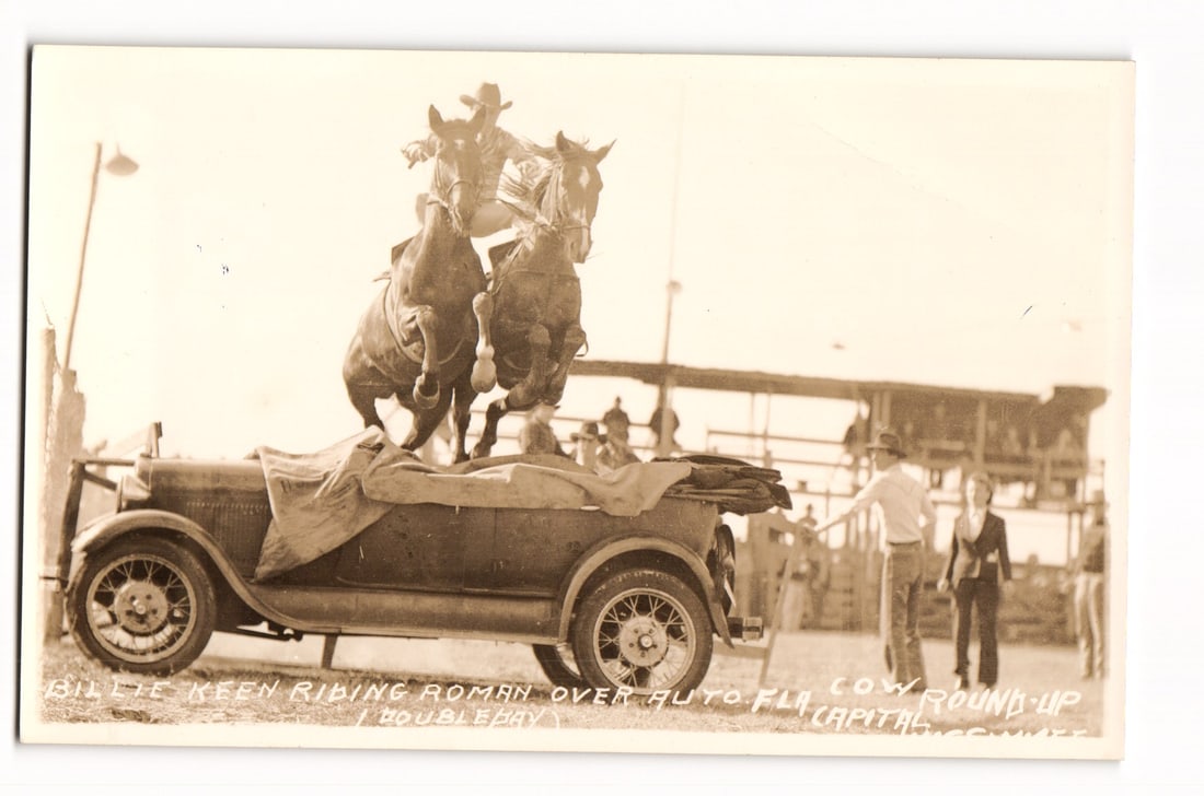 RPPC by RR Doubleday: Billie Keen Roman Riding Roman Over Auto Florida at Cow Round-Up, Capital, c.: An almost mint condition original sepia-toned Real Photo Postcard (RPPC) by Ralph R Doubleday, famed rodeo and round-up photographer, depicts an action scene where one Billie Keen is performing a Roma