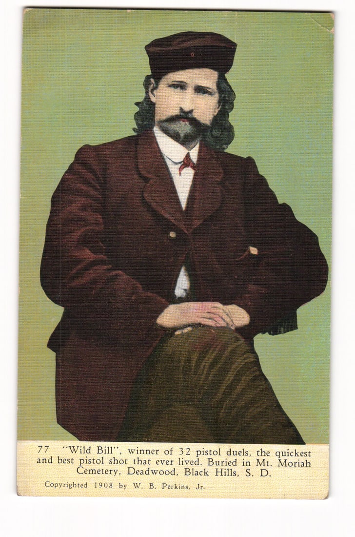 "Wild Bill", Winner of 32 Duels, Buried Mt. Moriah Cemetery, Deadwood, S.D. 1908 Postcard.: Waist-up portrait of a seated man, captioned on the front as "Wild Bill". He has dark shoulder-length hair, a mustache, and goatee; wears a dark billed cap, a dark single-breasted jacket over a white