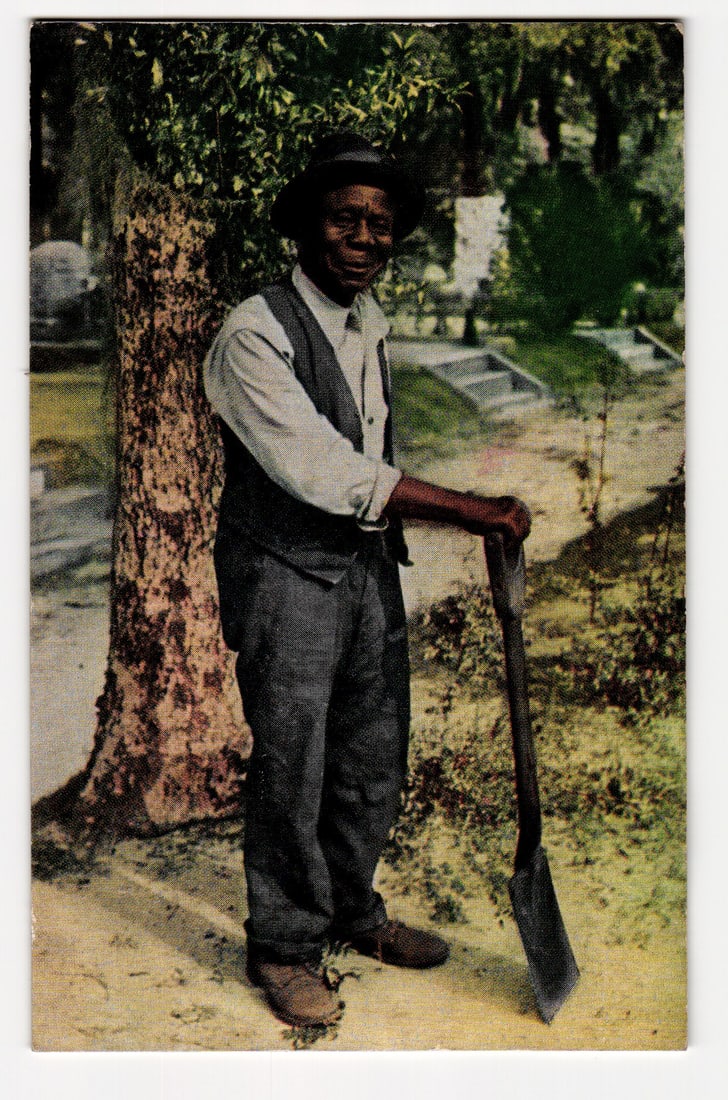 Man with Shovel, 'Old Black Joe', Colorized Photo by Bayard Wootten, Early-Mid 20th Century: The front of the postcard features a colorized photograph. The primary subject is an African American man, depicted full-length, standing outdoors. He wears a dark, wide-brimmed hat, a light-colored,
