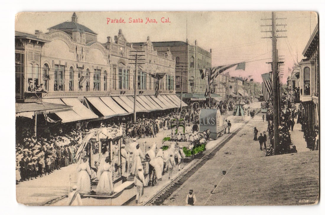 Santa Ana, Cal. Parade with ELKS Float and Crowds, M. Rieder Published Postcard No. 6616: A colorized print postcard. The image depicts a bustling street scene during a parade in Santa Ana, California. A procession features horse-drawn floats, with one prominently displaying an "ELKS" sign