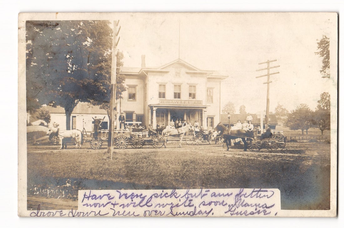 RPPC: J. Hawley Ltd. Building with Horse-Drawn Carriages, Stepney Depot, Conn. 1906 Postcard: A sepia-toned real photo postcard depicting a large, two-story wooden building with a gabled roof and multiple windows. The building's facade features a sign reading "J. HAWLEY LTD". In front of the b