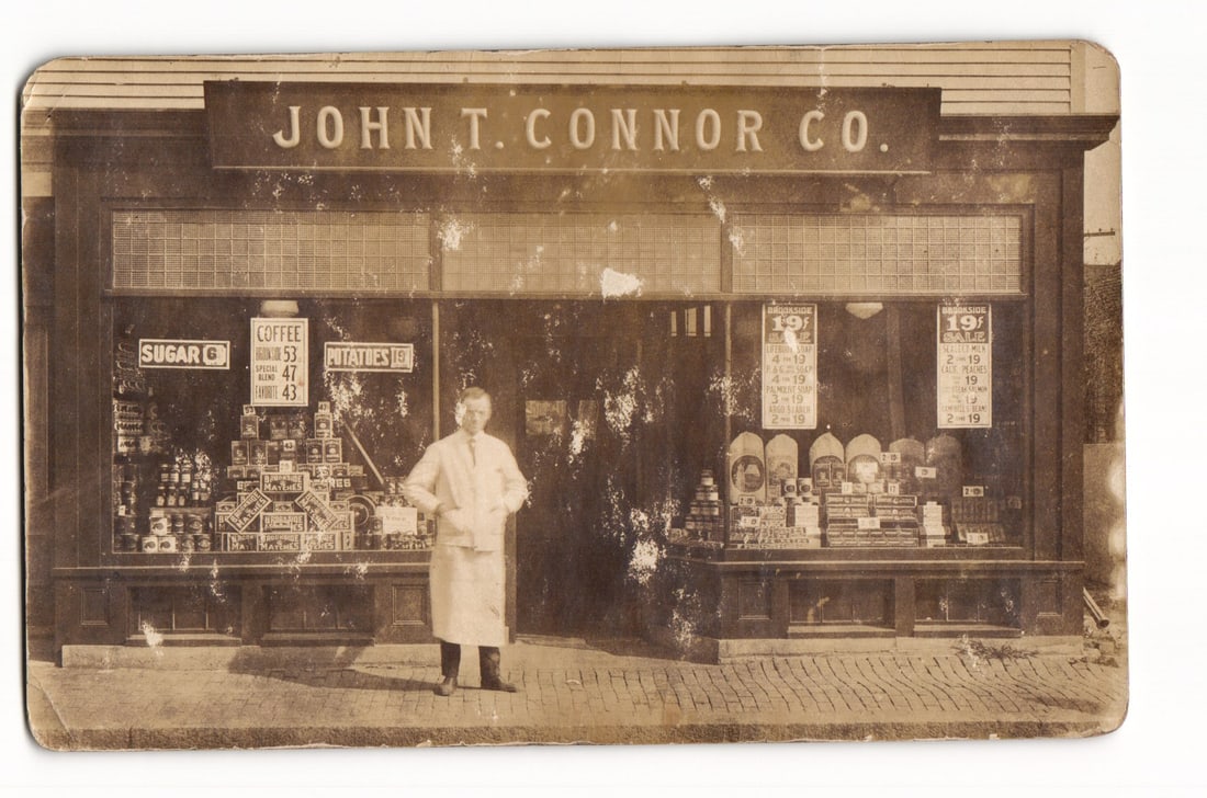 Real Photo Postcard: John T. Connor Co. Grocery Storefront, Man Posing, Sepia Photograph (1 of 2)