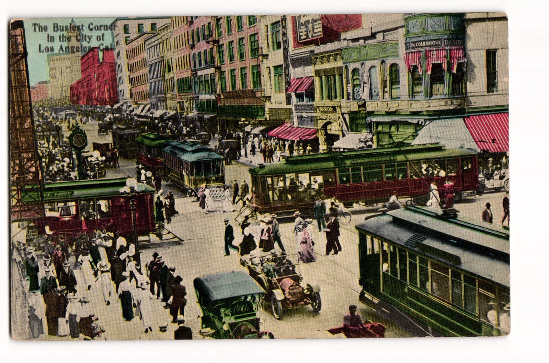 Los Angeles: The Busiest Corner, Streetcars, Automobiles, Pedestrians, Early 20th Century postcard: Colorized print, high-angle view of a bustling Los Angeles street intersection. Electric streetcars, early automobiles, and horse-drawn vehicles crowd the streets; pedestrians in early 20th-century at