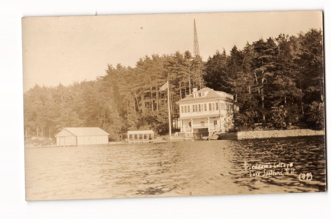 RPPC Friedman's Cottage, boathouses, US flag, radio tower, Lake Stafford, NH, ca. 1904-1918 view. (1 of 2)