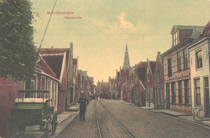 Postcard showing a street view of Noordeinde in Monnikendam, Netherlands with a man on tram tracks.