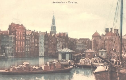 Postcard showing the historic Damrak canal in Amsterdam, Netherlands with barges and gabled houses.