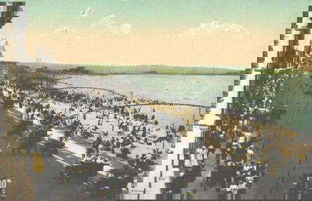 Postcard showing a bustling lakeside drive and beach scene with early autos and carriages, c. 1910s.