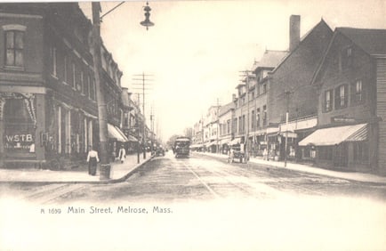 Postcard view of Main Street in Melrose, Massachusetts, with a central trolley and storefronts c.