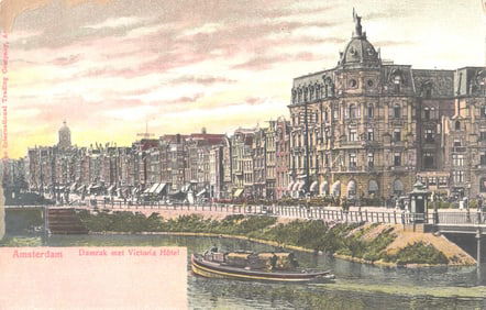 Color postcard of the Damrak with the Victoria Hotel and a canal boat in Amsterdam, Netherlands.
