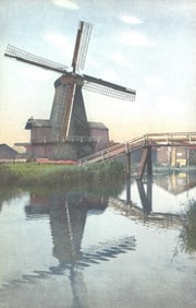 Photochrom postcard showing a Dutch windmill and footbridge reflected in a canal, Netherlands c.