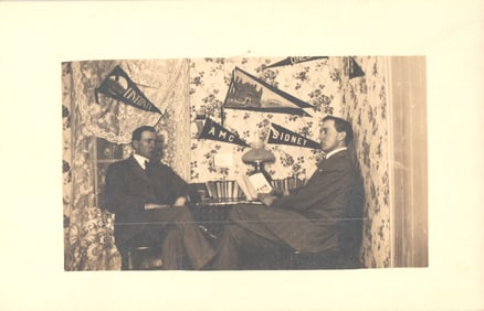 RPPC Real Photo Postcard of two men in a study decorated with Oneonta and Sidney, NY pennants
