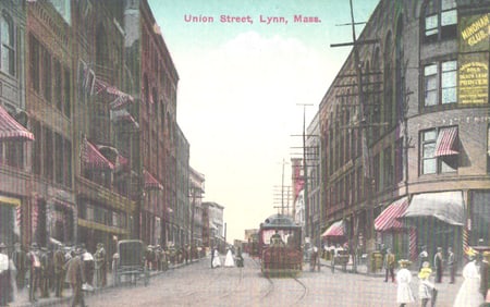 Postcard showing a bustling view of Union Street in Lynn, Massachusetts with a central trolley