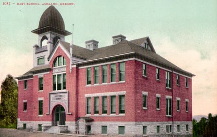 Postcard view of the East School, a red brick building with a domed tower, Ashland, Oregon c. 1910s.