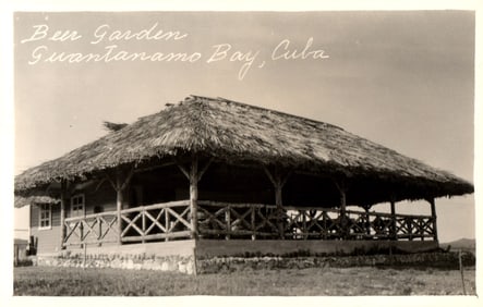 RPPC Real Photo Postcard of the Beer Garden at Guantanamo Bay, Cuba with its large thatched roof.