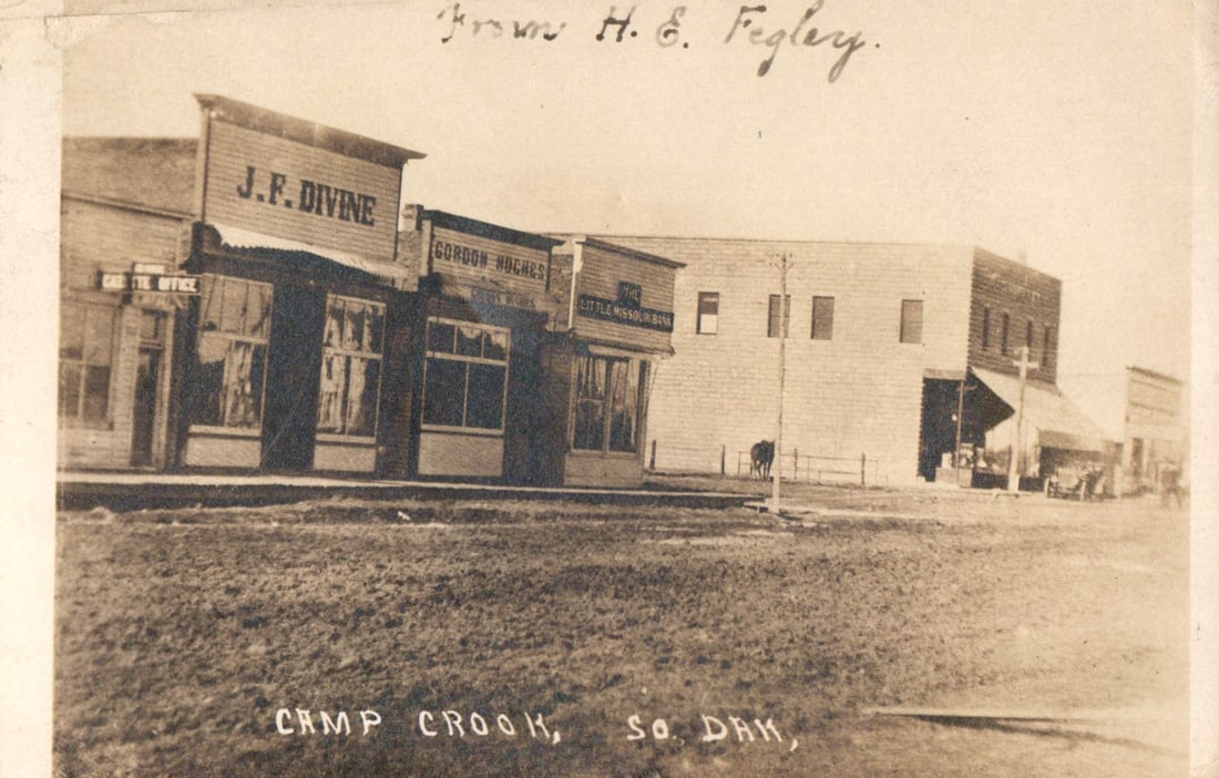 RPPC Real Photo Postcard of Camp Crook, South Dakota street view with J.F. Divine store, c. 1910. (1 of 2)