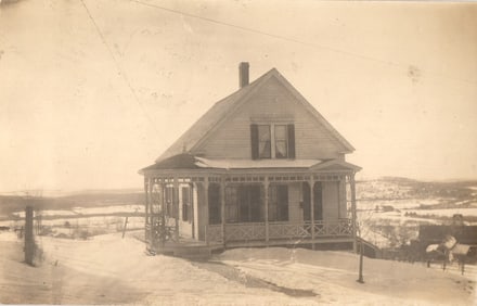 Real Photo Postcard of a home with a large porch in a winter landscape in Spencer, MA c. 1910s.