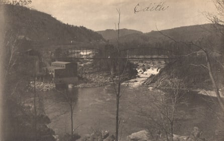 RPPC Real Photo Postcard of a scenic river, truss bridge, and riverside mill, circa 1910s.