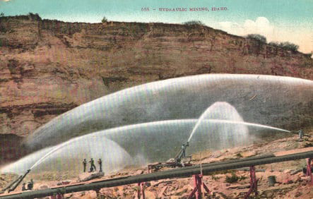Postcard depicting a large-scale hydraulic mining operation with powerful water jets in Idaho. c.