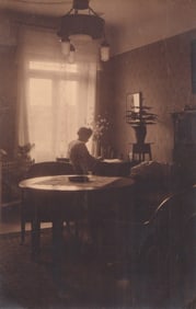 RPPC Real Photo Postcard showing a German domestic interior scene of a woman at her desk c.1912.