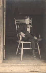 RPPC Real Photo Postcard showing a dapper young boy in a suit posing in a rocking chair c. 1910s