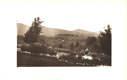 RPPC Real Photo Postcard showing a scenic mountain valley view from a garden with a small fountain.