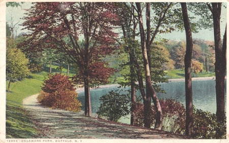 Postcard showing a lakeside path with autumn trees in Delaware Park, Buffalo, New York circa 1918.