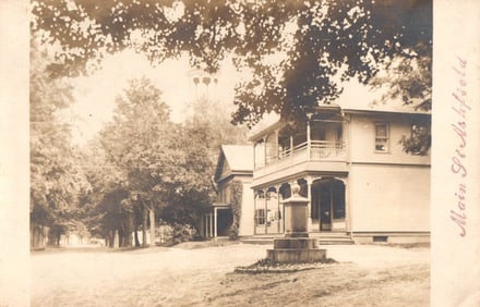 RPPC Real Photo Postcard showing a house and monument on Main Street in Ashfield, Massachusetts c.