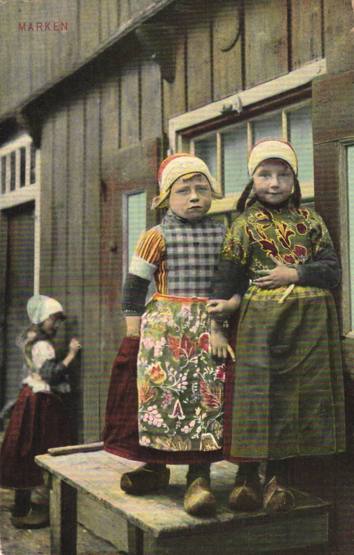 Postcard of three young girls in traditional Dutch folk costumes and clogs in Marken, Netherlands: Please view photos for further description and condition considerations. Please know the scans may be darker or lighter than the actual item's true appearance. ACME Auctions offers FREE DOMESTIC SHIPP
