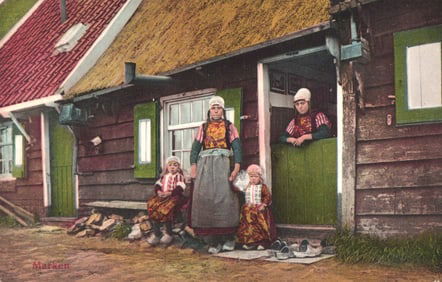 Postcard showing a Dutch mother and children in traditional dress outside their home in Marken,