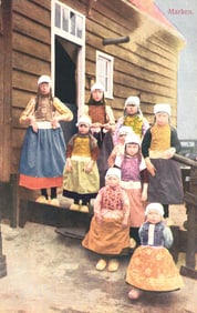 Colorized postcard of Dutch women and girls in traditional folk costumes and clogs, Marken, Holland.