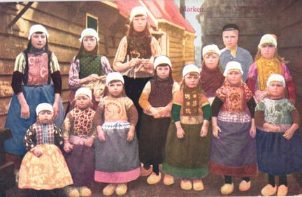 Colorized postcard of a group of Dutch children in traditional folk dress from Marken, Netherlands.