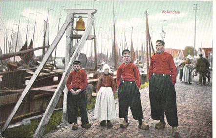 Postcard of three men and a girl in traditional Dutch costumes and clogs in Volendam harbor, ca