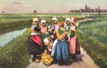 Photochrom postcard of young girls in traditional Dutch costumes playing a game in Marken, Holland