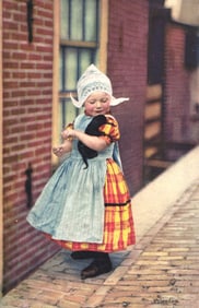 Photochromie postcard of a charming young girl in traditional Dutch Volendam costume holding a