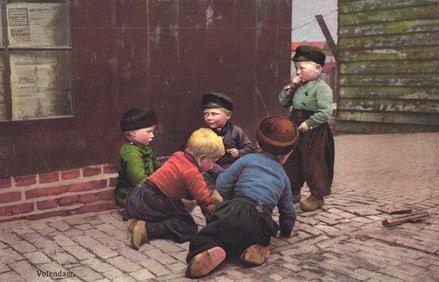 Postcard showing young boys in traditional Dutch clothing and wooden clogs playing on a street in