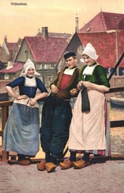 Photochrom postcard of a man and two women in traditional Dutch folk costumes in Volendam, Holland.