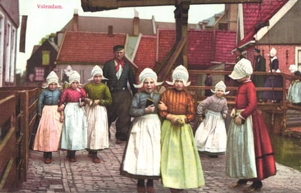 Photochromie postcard showing Dutch children in traditional costumes on a wooden bridge in Volendam.
