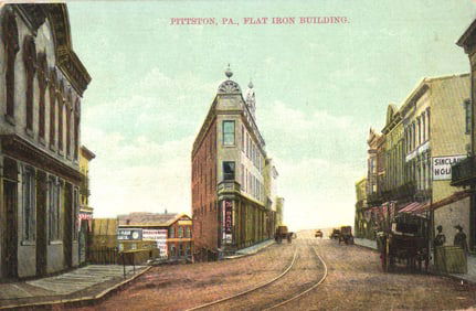 Postcard showing the Flat Iron Building in Pittston, PA, a busy street scene with trolleys c. 1909.