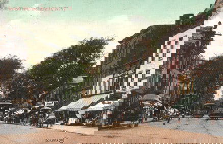 Postcard of Peekskill, New York's bustling South Street with trolleys and horse-drawn carriages.