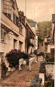 Postcard depicting the famously steep and cobbled High Street in Clovelly, Devon, England with